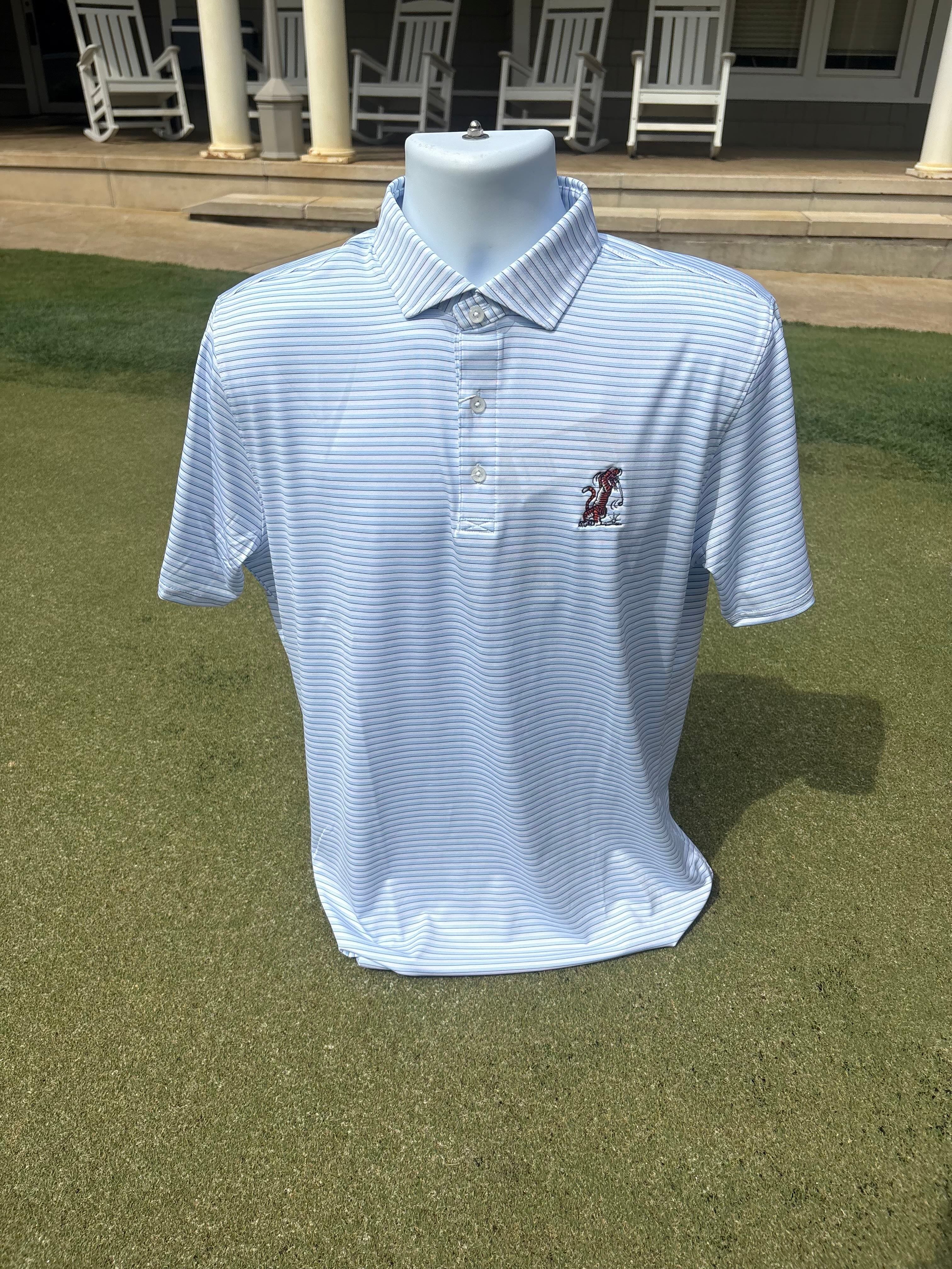 A light blue and white striped short-sleeve polo shirt displayed on a white mannequin torso, set on a green grass lawn with a house porch and patio chairs in the background.